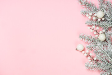 Christmas decorations at pink background. Fir tree and white christmas decorations top view with copy space.