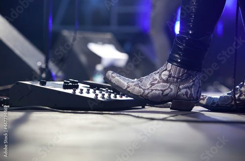 Rock guitarist playing with pedalboard photo