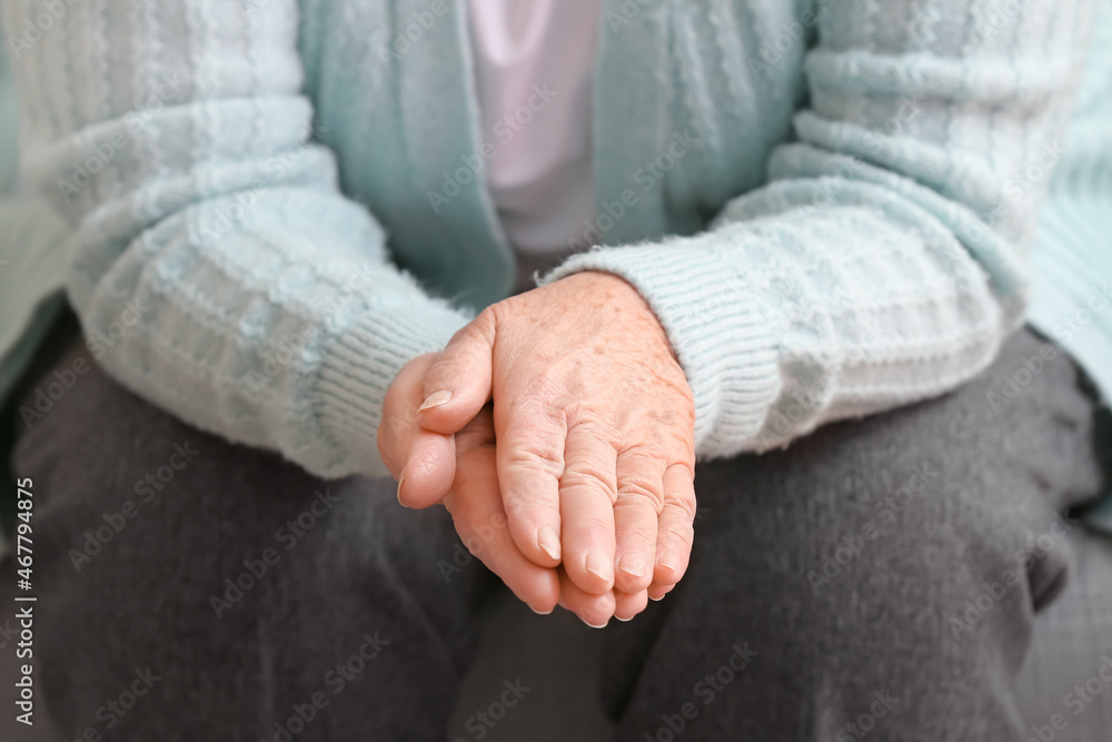 Hands of elderly woman sitting at home, closeup