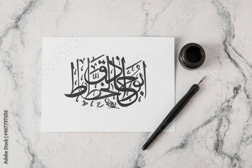 Obraz na plátně Paper with Arabic text and tools for calligraphy on light background