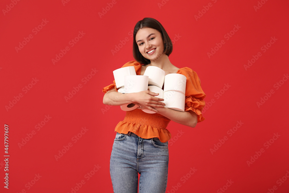 Young woman with many rolls of toilet paper on color background Young woman with many rolls of toilet paper on color background