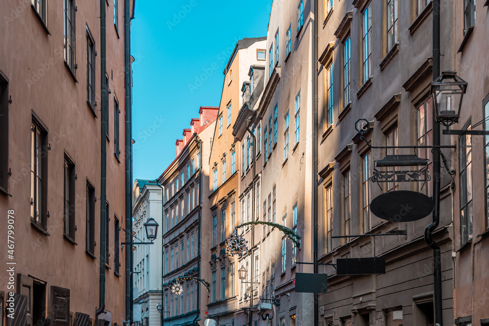 Narrow streets with New Year's, Christmas decorations, festive garlands and stars on the facades of old houses on the streets in Gamla Stan, Stockholm, Sweden