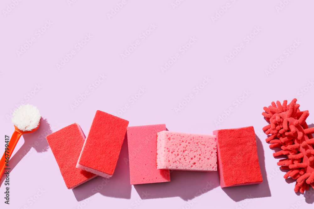 Cleaning sponges and brush on pink background