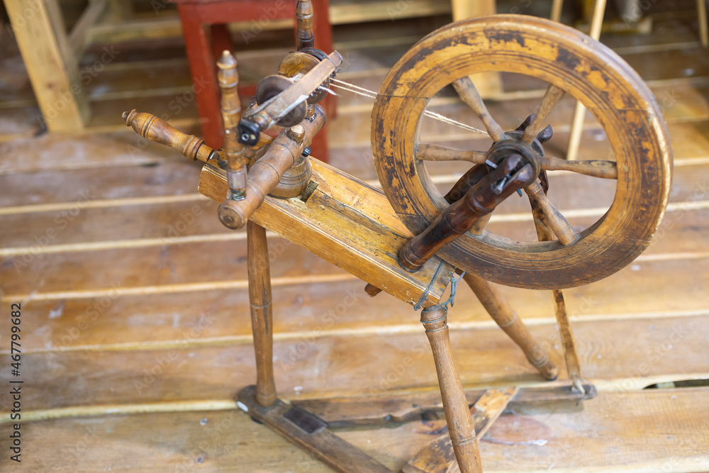 Antique spinning wheel made of wood for making wool yarn.