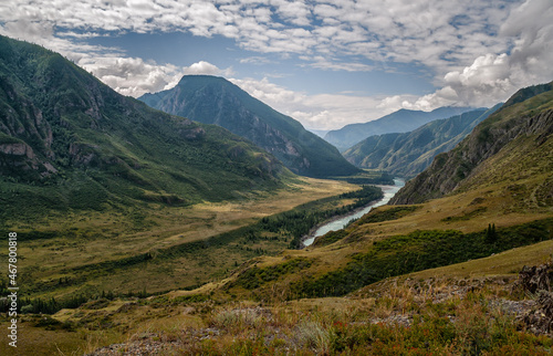 panorama of the summer landscape in the mountains. The valley of the mountain river Katun turquoise. the river flows between mountains and wide fields. blue sky and clouds view from high point