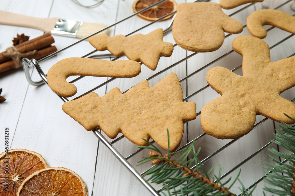 Fototapeta premium Grid with Christmas gingerbread cookies and spices on light wooden background, closeup