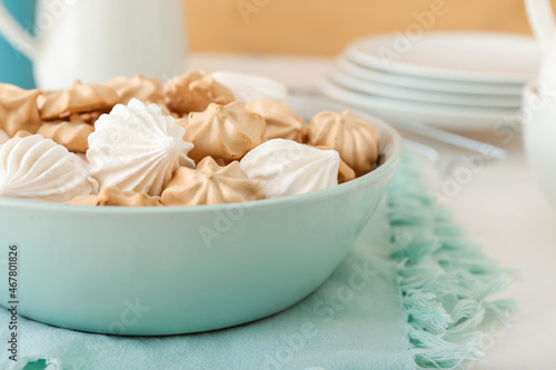 Bowl with tasty meringues on table, closeup