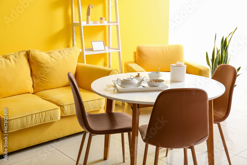 Interior of bright yellow dining room with table