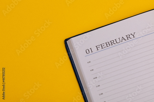 Notepad or diary with the exact date on a yellow background. Calendar for February 1 - winter time. Space for text. photo