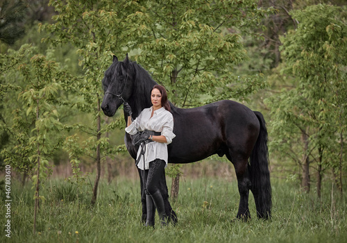 Beautiful long-haired girl with a Friesian horse © Елизавета Мяловская