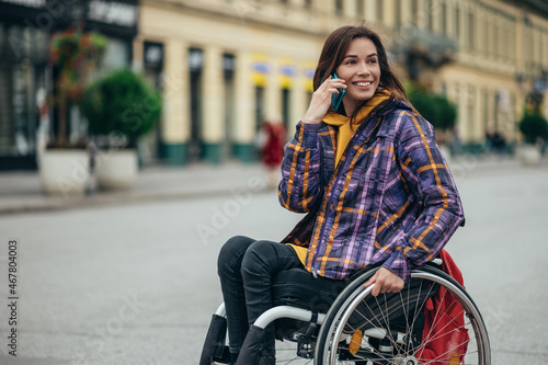 Woman with disability using a smartphone while out in the city