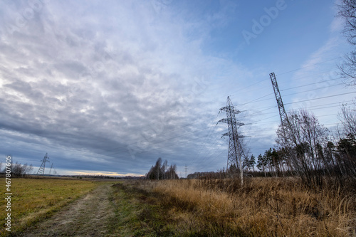Power lines on the background of the sunset sky, on a cool evening. Picturesque autumn landscape with electric transmission line supports. © Sergei