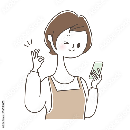 スマートフォンを持ってOKサインを出す女性