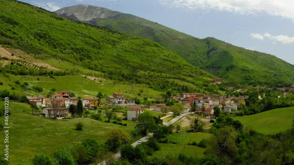 Aerial: Beautiful Shot Of Built Structures On Hills, Car Moving On Road Amidst Green Landscape - Apennine Mountains, Italy Aerial: Beautiful Shot Of Built Structures On Hills, Car Moving On Road Amidst Green Landscape - Apennine Mountains, Italy