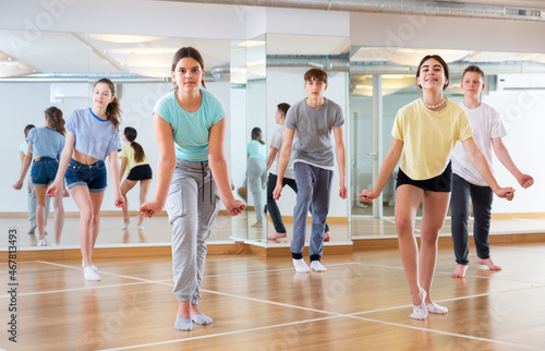 Positive smiling slim teenagers dancing hip hop in dance class