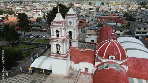 Church in State of Mexico on the day with blue sky and white clouds, cinematic aerial footage with drone in a small town with decoration of tematic party of saints photo