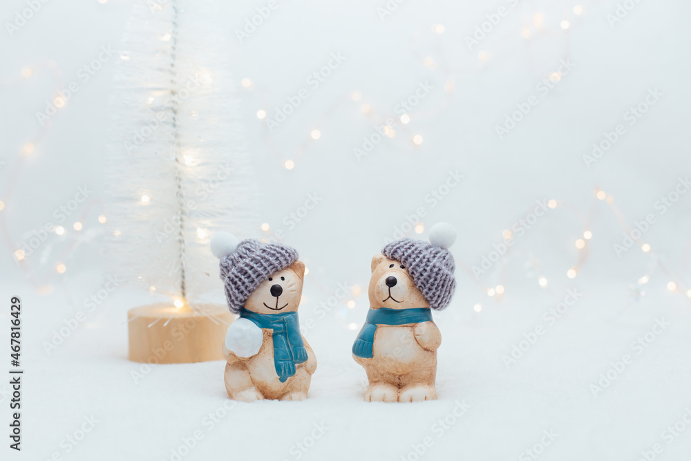 Decorative Christmas-themed figurines. The statuette of a cat and a bear in a knitted hat on the white background.