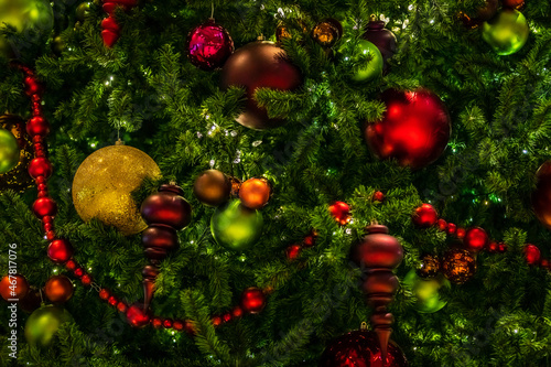 Red and green christmas ornaments nestled in a christmas tree