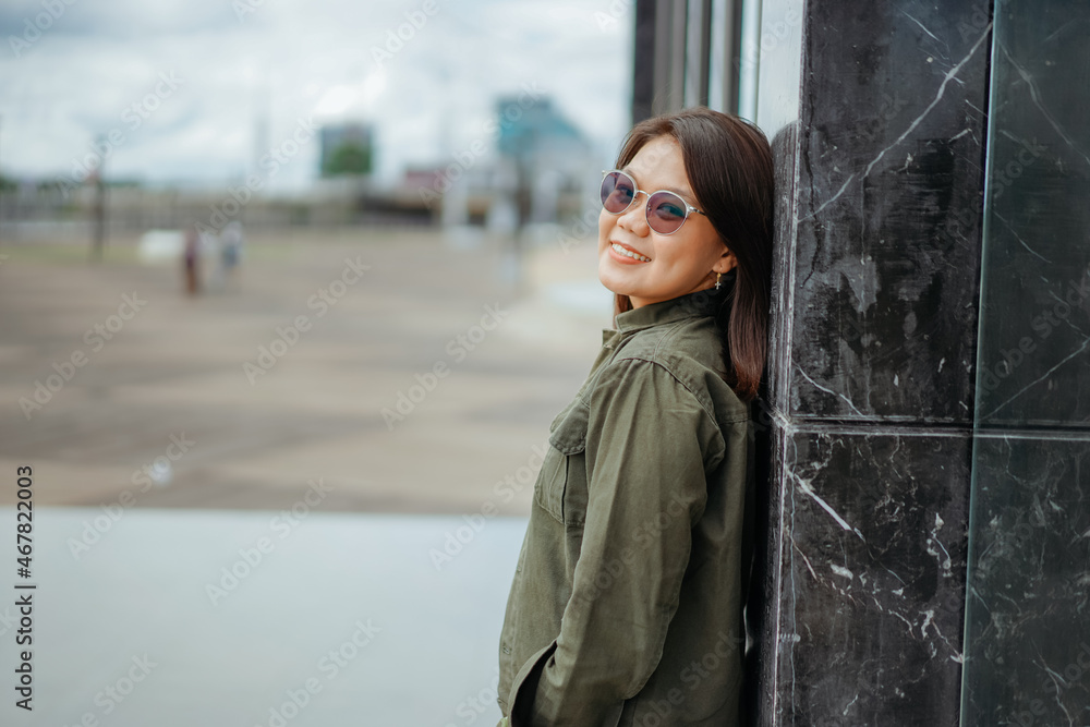 Obraz premium Young Beautiful Asian Woman Wearing Jacket And Black Jeans Posing Outdoors