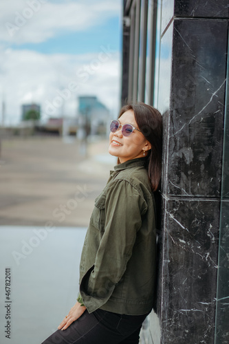 Young Beautiful Asian Woman Wearing Jacket And Black Jeans Posing Outdoors