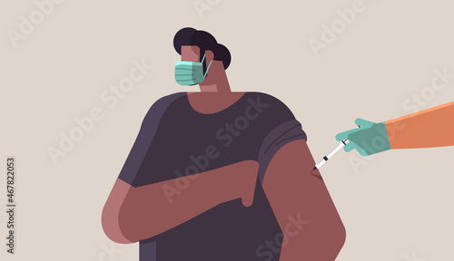 doctor hand vaccinating african american male patient in medical mask fight against coronavirus vaccine development