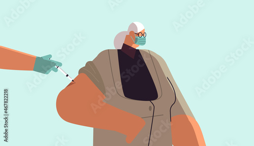 doctor hand vaccinating female patient in medical mask fight against coronavirus vaccine development concept