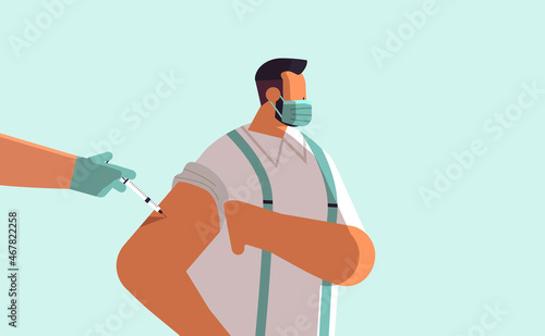 doctor hand vaccinating male patient in medical mask fight against coronavirus vaccine development concept