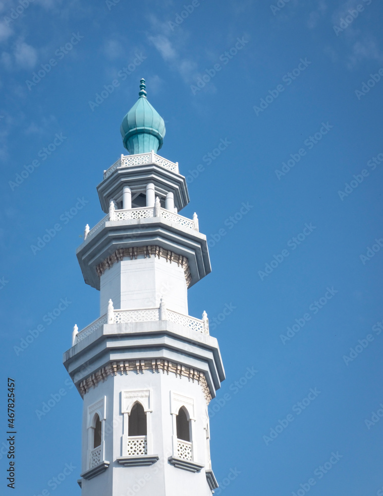 Mosque minaret against blue sky. Copy space.