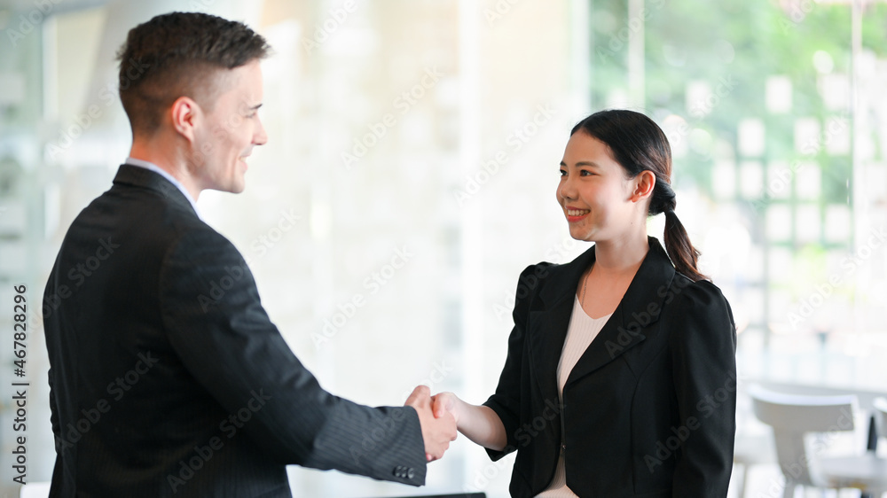 Caucasian male boss greeting and handshaking new employee Caucasian male boss greeting and handshaking new employee