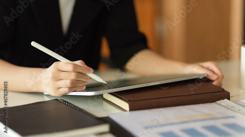 Businesswoman using stylus pen to write on touchpad