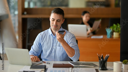 Male employee open speaker phone while calling with business client