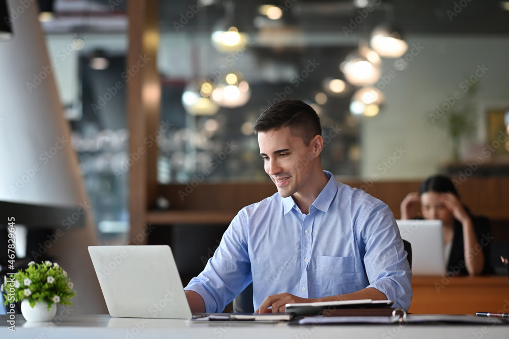 Fototapeta premium Handsome businessman working with laptop computer in modern office.