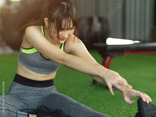 Fit woman cool down after workout, exercise stretching her leg.