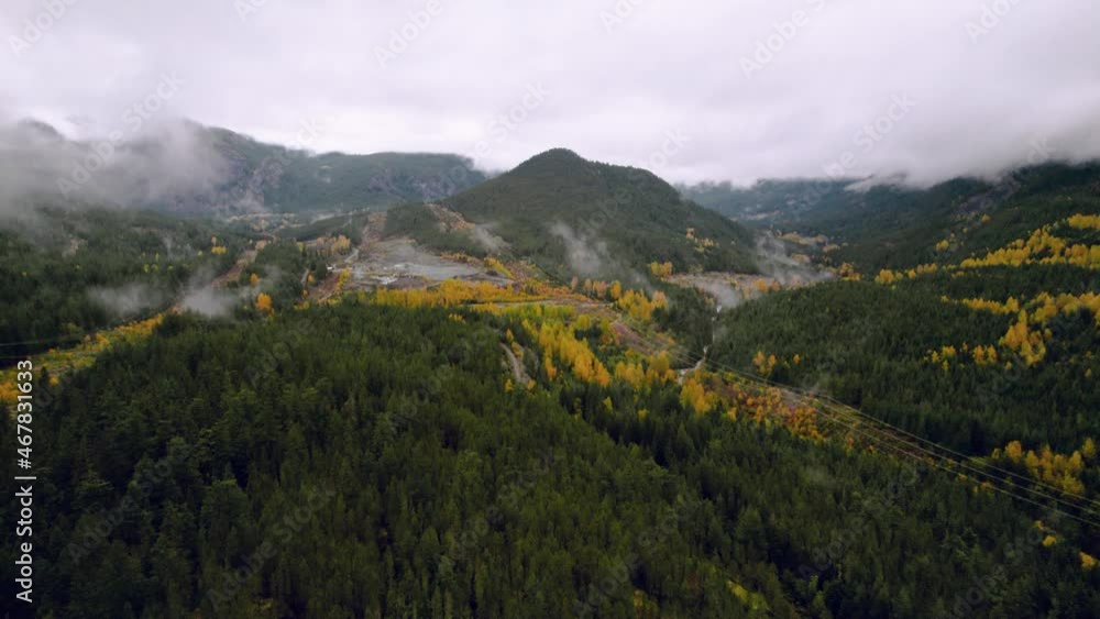 Cinematic Drone shot Reveal of Foggy Forest Mountain in Fall with yellow trees Evergreens and rolling Clouds flyover (4K) Cinematic Drone shot Reveal of Foggy Forest Mountain in Fall with yellow trees Evergreens and rolling Clouds flyover (4K)