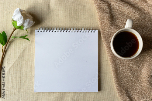 top view of an open notebook with blank pages next to a cup of coffee for adding text or layout