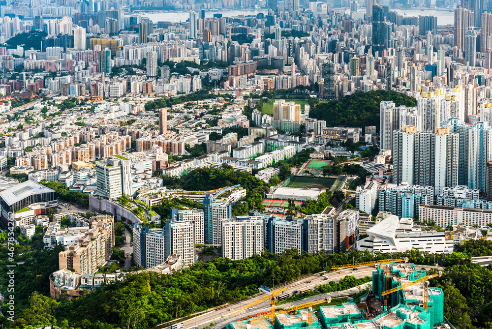 Naklejka premium Panorama aerial view of Hong Kong Kowloon's crowded buildings and Victoria Harbour in China.