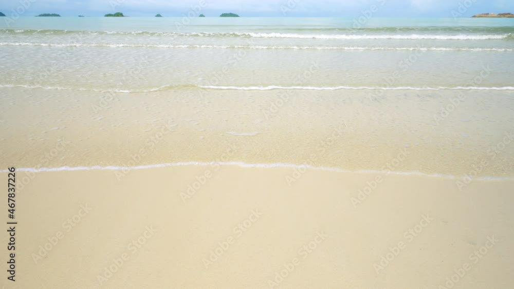 Close up beach sand with water wave in summer day. Empty beach copy space or frame work of water and sand for background. Travel to relax with natural sea and ocean in holiday. Slow motion.