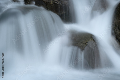 Wild mountain river in the mountains. Long exposure waterfall. Mountain river in the Alps long exposure. Flowing water over rocks  motion blur. Cold  clear water in the Italian Alps.