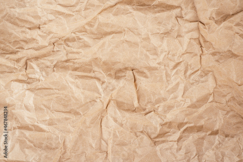 Background image of rough crumpled recycled textured kraft paper. Top view, copy space
