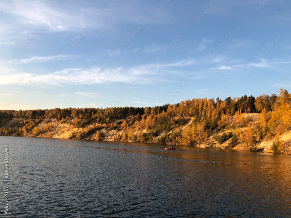 Fototapeta premium autumn forest on Dzerzhinsky lake, sunny evening