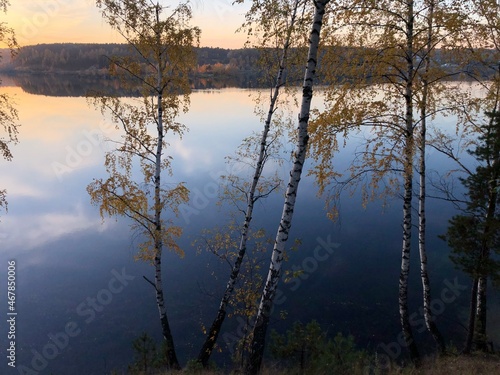 sunset on the lake in the middle of the forest in autumn