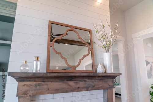 Decorative mirror on top of fireplace wooden frame inside living room of home