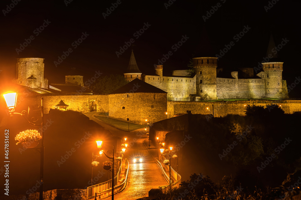 Night panoramic view of medieval castle in Kamenetz-Podolsk (Kamianets-Podilskyi), Ukraine. Light fog. Night panoramic view of medieval castle in Kamenetz-Podolsk (Kamianets-Podilskyi), Ukraine. Light fog.