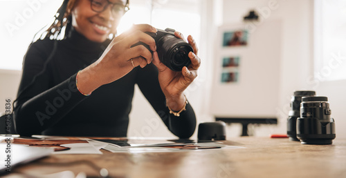 Woman holding a dslr camera in her home office photo