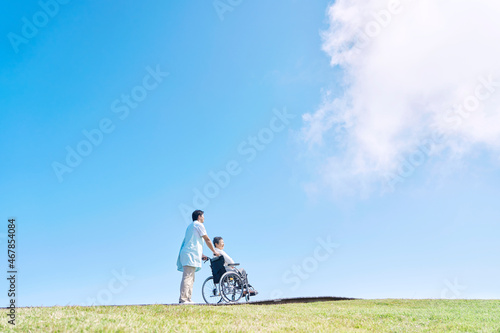 Fotografiet 介護士と車椅子に乗る高齢者　屋外