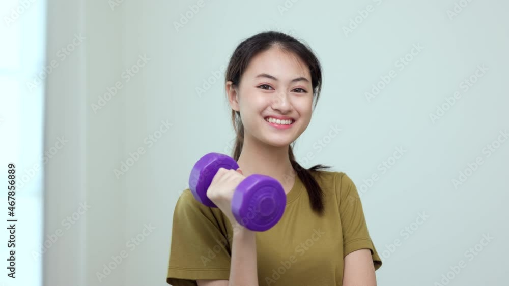 Attractive asian young fitness woman lifting dumbbell weights workout at home in living room. Fresh feeling female training and exercise wearing sport wear fit body. Attractive asian young fitness woman lifting dumbbell weights workout at home in living room. Fresh feeling female training and exercise wearing sport wear fit body.