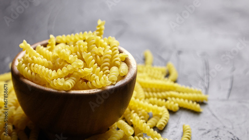 Girandole pasta in wooden bowl on black table