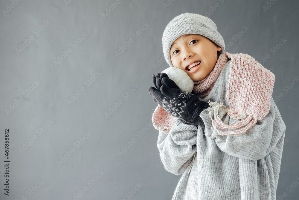 A boy wearing winter clothes and playing snow ball A boy wearing winter clothes and playing snow ball