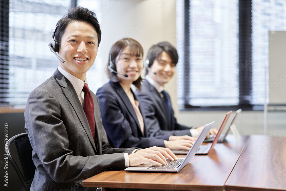 カスタマーセンターで応答するアジア人ビジネスパーソン