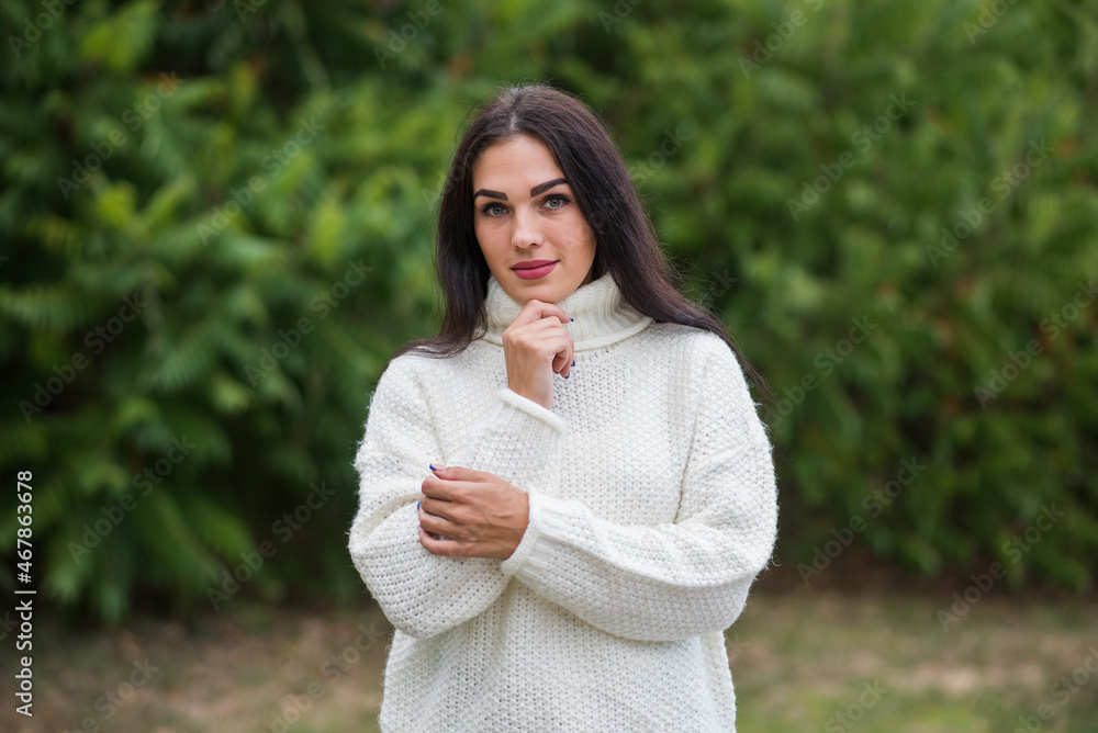Portrait of a young, happy and attractive Caucasian brunette girl in a white sweater Portrait of a young, happy and attractive Caucasian brunette girl in a white sweater